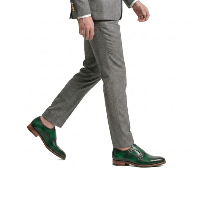 Green monk strap formal shoes paired with grey suit trousers elegant styling