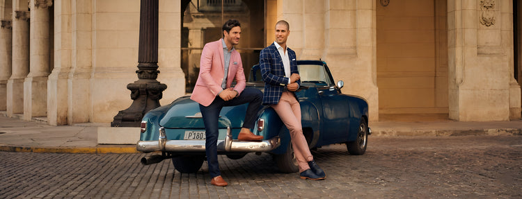 Men wearing Italian designer leather shoes with luxury smart casual fashion styling beside a vintage car outdoors