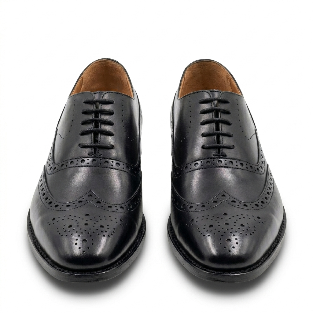 Front view of handcrafted black leather wingtip brogue Oxford shoes for men, showcasing intricate perforation details and a polished finish on a white background.