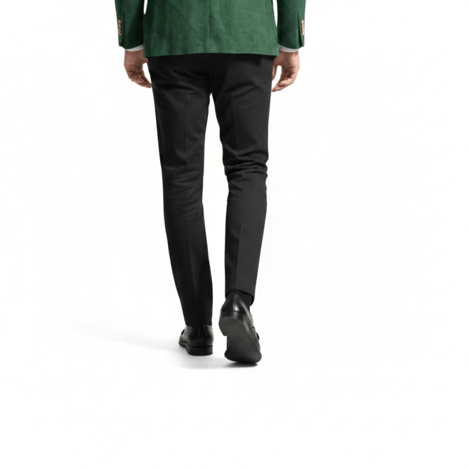 Rear view of a person wearing black leather dress shoes with black trousers and a green blazer.