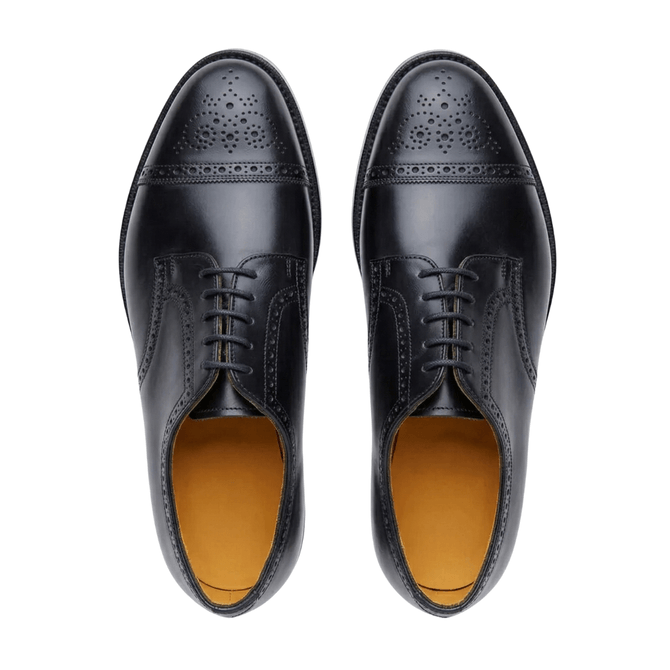 Top-down view of men's classic black leather oxford shoes with wingtip broguing, set against a clean white background.