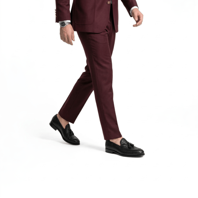 Man styling black woven tassel loafers with a tailored maroon formal suit