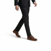 Close up of man wearing cognac brown leather wingtip brogue dress shoes with a charcoal suit.