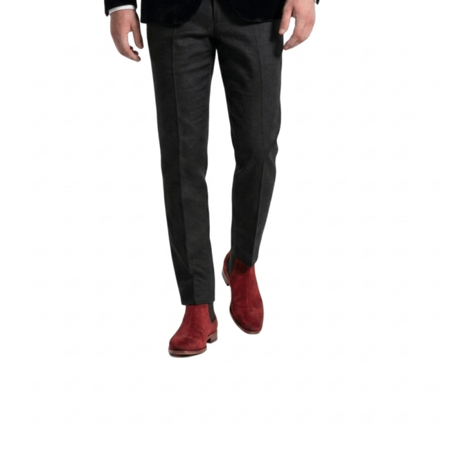 Men's luxury burgundy suede Chelsea boots styled with a black suit, captured from a front-facing walking perspective.
