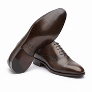 Brown leather Oxford shoe showing the sole and side profile