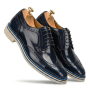Dynamic floating shot of navy blue wingtips highlighting the vibrant blue stripe in the midsole and classic lacing.