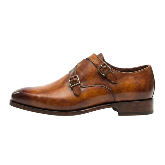 Medial profile of men's handcrafted tan leather double monk strap shoes with a refined almond toe and stacked leather heel.