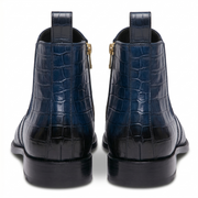 Rear view of navy blue leather boots showing the pull tab and the polished black finish on the heel.