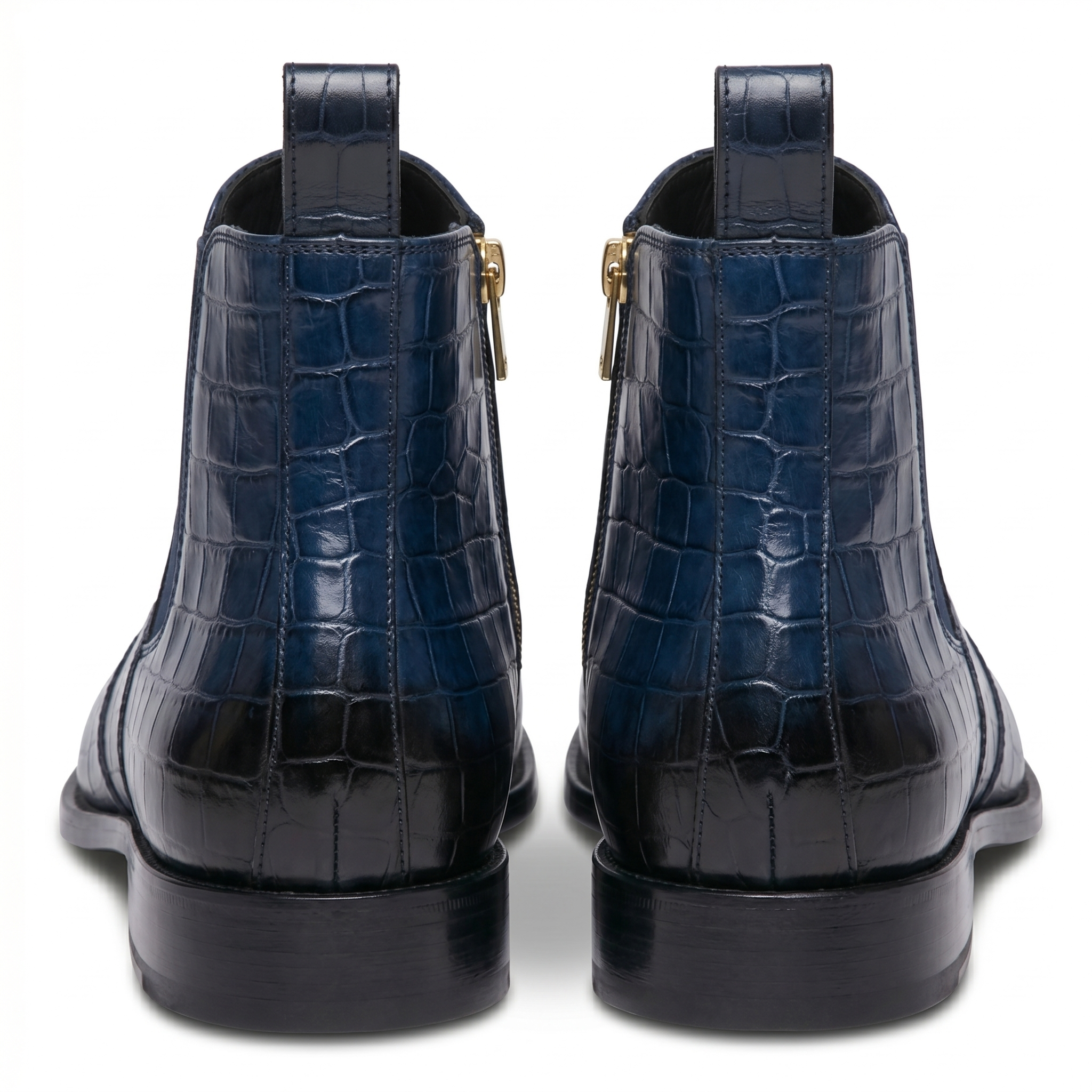 Rear view of navy blue leather boots showing the pull tab and the polished black finish on the heel.