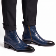 Close-up of navy blue crocodile-textured boots worn with black tailored trousers for a formal look.