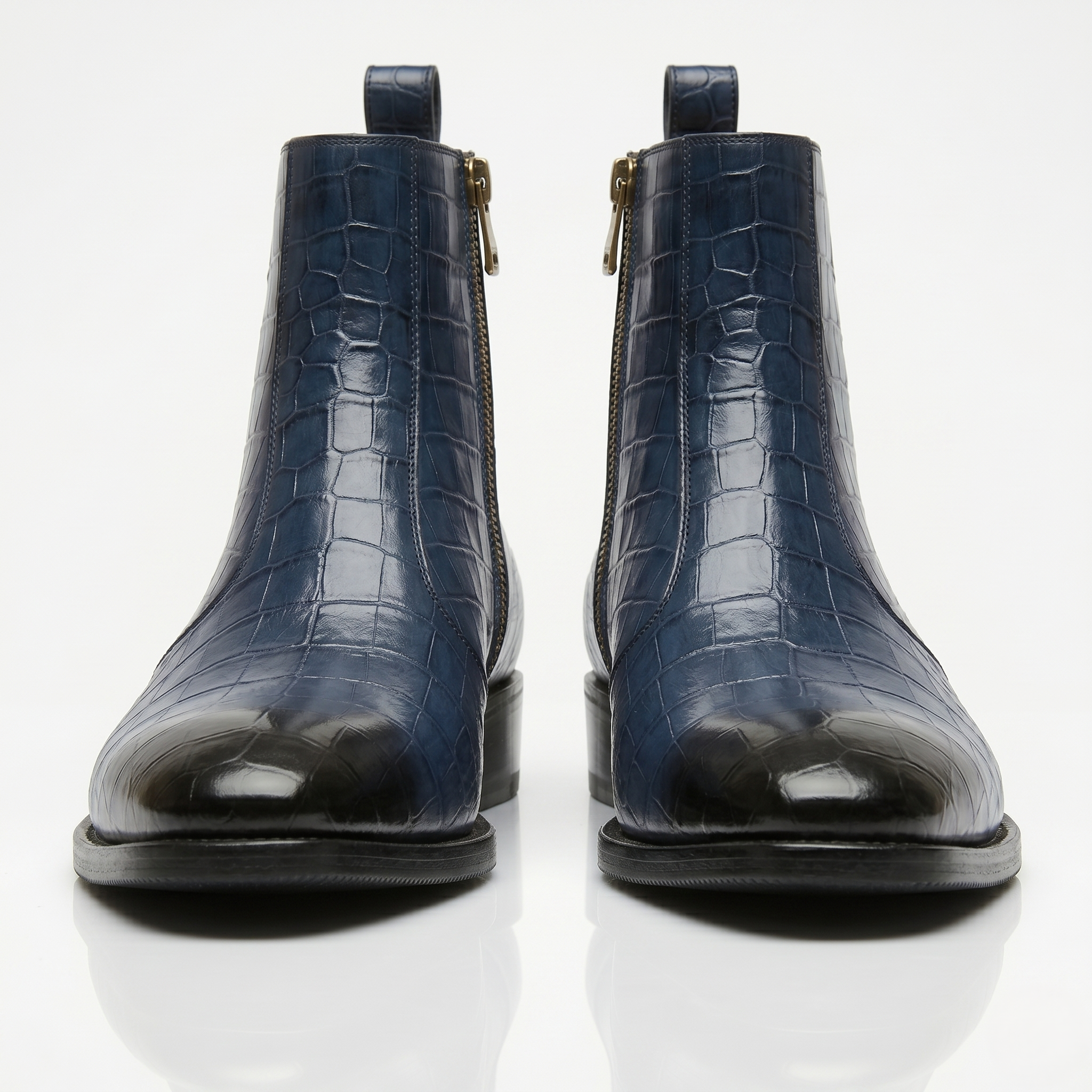 Front-facing shot of navy blue leather boots highlighting the black gradient cap toe and symmetrical design.