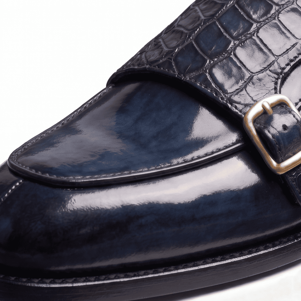 Close-up front view of navy blue double monk strap shoe with croco leather texture