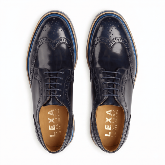Birds-eye view of navy leather brogues showing the symmetrical wingtip design and gold-branded tan leather insoles.
