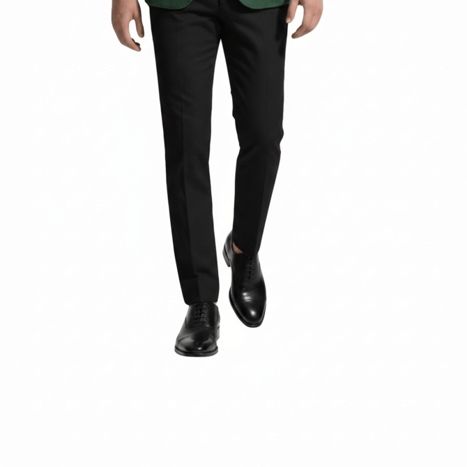 Front view of black leather wholecut Oxford shoes styled with slim-fit black dress pants.